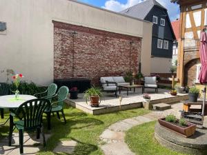 a patio with chairs and tables and a brick wall at FEWO Blockstube Frieda in Kottmar
