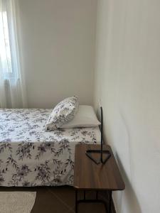 a small bedroom with a bed and a wooden table at Pasa da sí in Alba