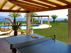 a ping pong table on the patio of a house at Villa Alexandros in Spartià