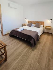 a bedroom with a large bed and wooden floors at Casa Rural Las Alcusa in Cubla