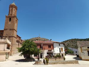 a town with a clock tower and a church at Casa Rural Las Alcusa in Cubla