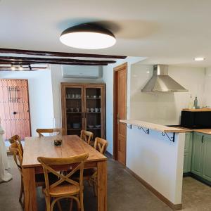 a kitchen with a wooden table and some chairs at Casa Rural Las Alcusa in Cubla