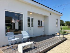 two chairs and a bench on a wooden deck at Cafe & Stay Flyway in Ogata