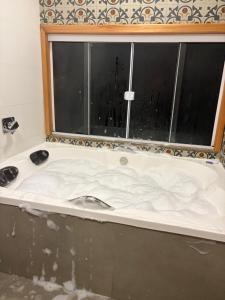 a bath tub in a bathroom with a window at Cabana Raízes da Mata - Hidro e Natureza in São Joaquim +19 photos