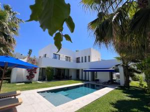 a large white house with a swimming pool at Dar El Musc Chambres d'hôtes in Sukrah
