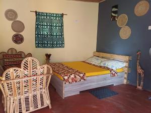 a bedroom with a bed and two chairs and a window at Jedd Palace in Kpannou