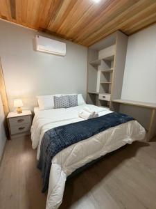 a bedroom with a large bed and a book shelf at Cabana Raízes da Mata - Hidro e Natureza in São Joaquim