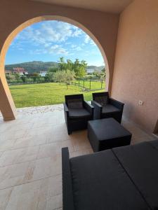 a patio with couches and chairs and a large window at Casa nel verde in Bar