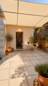 a patio with chairs and a table and a building at Camvas Apartments in Panormos Kalymnos