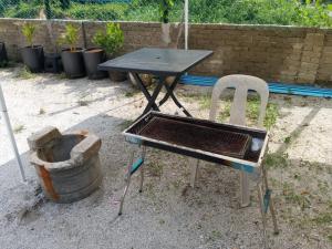 a table and a chair next to a table and a bucket at Desa Landak Chalet in Jertih