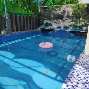 a swimming pool with two frisbees in the water at Desa Landak Chalet in Jertih