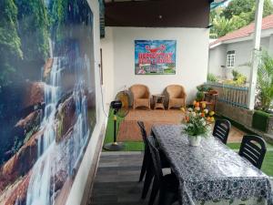 a patio with a table and chairs and a movie poster at Desa Landak Chalet in Jertih