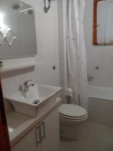 Villetta Indipendente Sardegna في فيلابوتزو: حمام مع حوض ومرحاض وحوض استحمام
