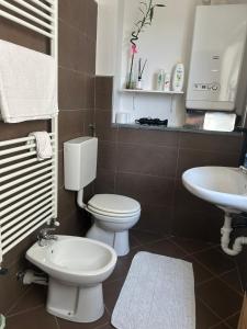 a bathroom with a toilet and a sink at Pasa da sí in Alba +3 photos