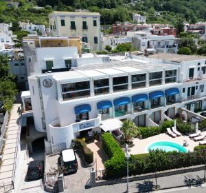 an aerial view of a white building with blue awnings at Bougainville Luxury Boutique Hotel in Anacapri