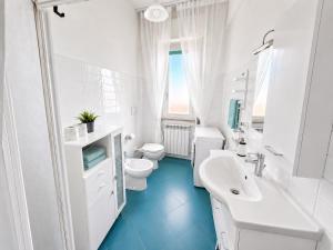 a white bathroom with a sink and a toilet at Vista Mare, Netflix & AC - Smeraldo Apartment in Laigueglia +2 photos