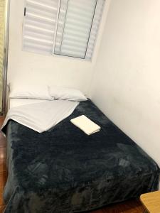 a bed in a small room with a window at kitnet 101 mob in Tatuí +3 photos