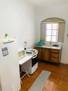 a kitchen with a stove and a sink and a microwave at kitnet 101 mob in Tatuí