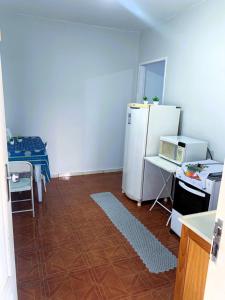 a kitchen with a white refrigerator and a table at kitnet 101 mob in Tatuí