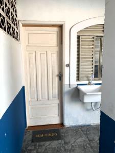 a door to a bathroom with a sink at kitnet 101 mob in Tatuí