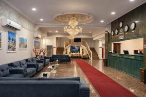 a lobby with blue couches and a red rug at Al Diyar Hotel in Nizwa