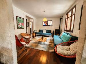 ein Wohnzimmer mit einem blauen Sofa und Stühlen in der Unterkunft MedioMundo Hostel in Montevideo