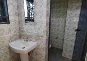 a bathroom with a sink and a shower at SKYFORCE Bénin - Agatha in Porto-Novo +5 photos