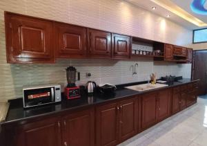 a kitchen with wooden cabinets and a counter top at SKYFORCE Bénin - Agatha in Porto-Novo