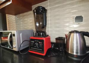 a red blender sitting on a counter next to a microwave at SKYFORCE Bénin - Agatha in Porto-Novo