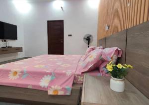 a bedroom with a pink bed with flowers on it at SKYFORCE Bénin - Agatha in Porto-Novo