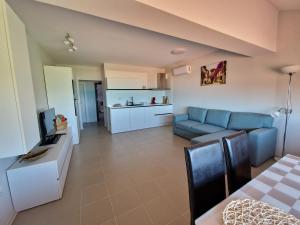 a living room with a blue couch and a kitchen at INFINITY VIEW 8 Lozenets in Lozenets