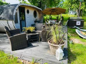 a patio with an umbrella and chairs and a table at Muhu Leeni Glamping in Kuivastu
