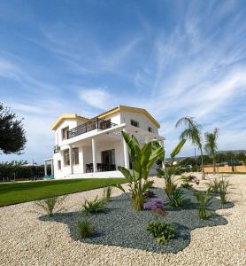 a white house with a lot of plants in front of it at Mariandy Villa 2 in Coral Bay