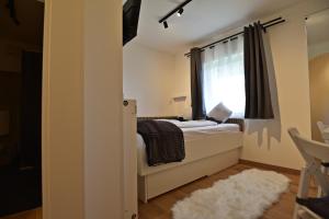 a small bedroom with a bed and a window at Ries Rosina - bei LKH GRAZ - NEUERÖFFNUNG - Self Check In 24-7 in Graz