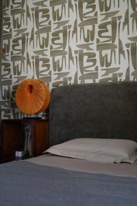 a bedroom with a bed and a wall with a lamp at logement avec jardin de bord Mer PORT NAVALO in Arzon