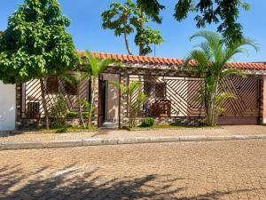 a building with palm trees in front of a street at Cintya Maria in Camama