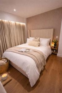 a bedroom with a large bed with white sheets at 1 Bridge Rd in Cranleigh +7 photos
