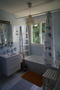 a bathroom with a tub and a sink and a window at logement avec jardin de bord Mer PORT NAVALO in Arzon +40 photos