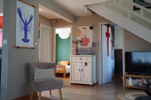 a living room with a tv and a chair at logement avec jardin de bord Mer PORT NAVALO in Arzon