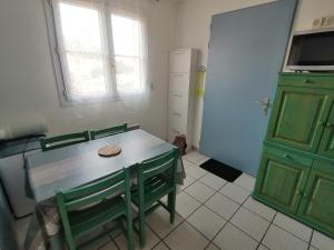 a kitchen with a table and a green cabinet at Port Aloès in Cerbère