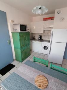 a kitchen with a green cabinet and a microwave at Port Aloès in Cerbère