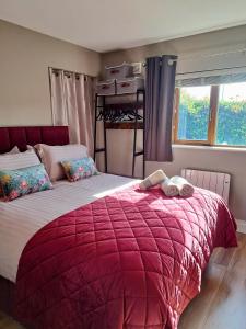 a bedroom with a large bed with a red blanket at 9 Suíomh Alainn in Kilgarvan