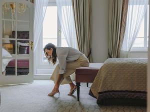 a woman kneeling on a bed in a hotel room at Fairmont Hotel Vier Jahreszeiten in Hamburg +138 photos