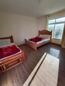 a room with two beds and a window at Homeland Hotel and Resort in Burāwai