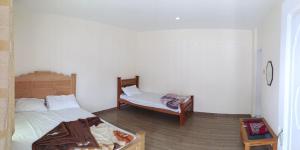 a bedroom with two beds and a table with a table at Homeland Hotel and Resort in Burāwai