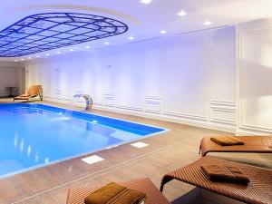 a large swimming pool in a room with a ceiling at Fairmont Grand Hotel Kyiv in Kyiv
