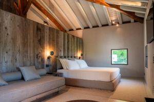 a bedroom with a large bed and a couch at Relais Borgo Taurino in Valdobbiadene +48 photos
