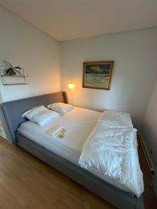a bedroom with a bed with white sheets at Sweet Home in Aarhus