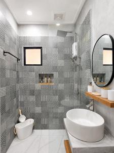 a bathroom with a tub and a sink and a mirror at White Palm Villa 1 in General Luna