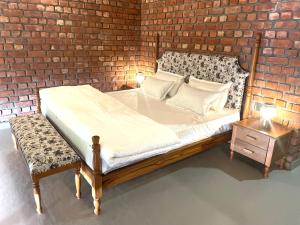 a bed in a room with a brick wall at Devshal Eco-Stays in Gupta Kāshi